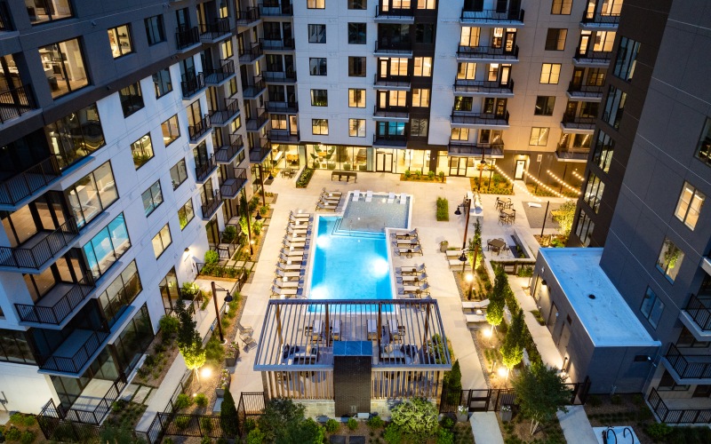 Aerial drone shot of pool with sundeck and exterior building